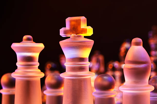 glas schach auf der schachbrett-hell blau und orange licht - armed forces black yellow chess pawn stock-fotos und bilder