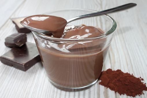 chocolate pudding in a glass bowl on a grey wooden table