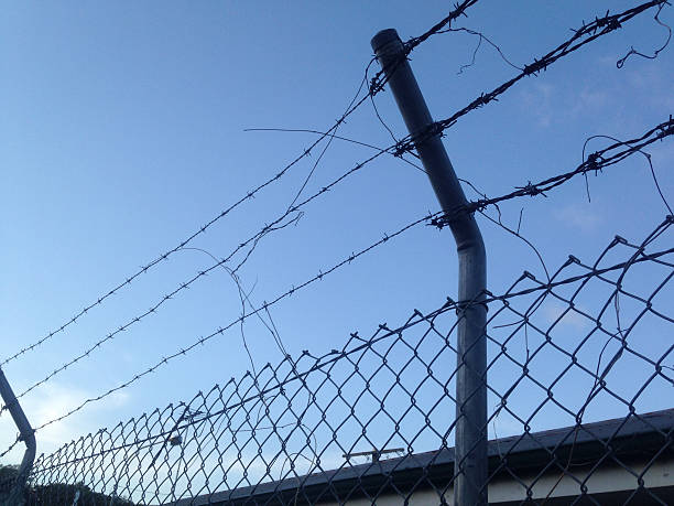 istock Barbed wired fence look up to see blue sky 470862578