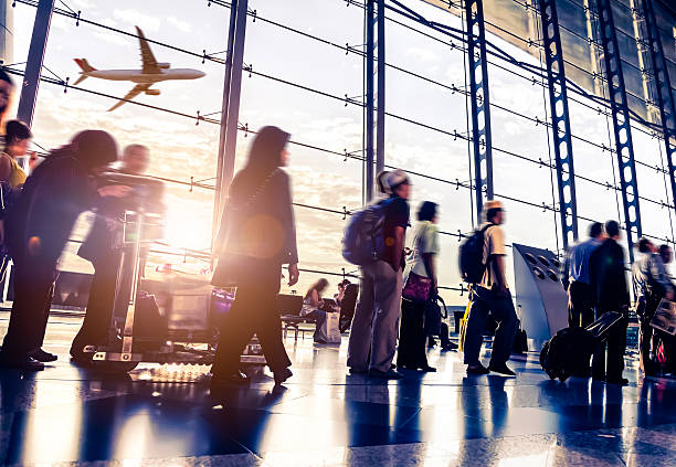 blurred shot of people walking through malaysia airport - havaalanları stok fotoğraflar ve resimler