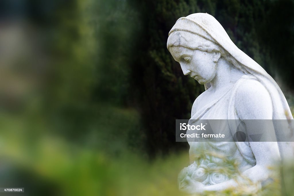 woman sculpture of marble in a park or cemetery woman sculpture with rose basket made of marble in a park or cemetery, copy space Statue Stock Photo