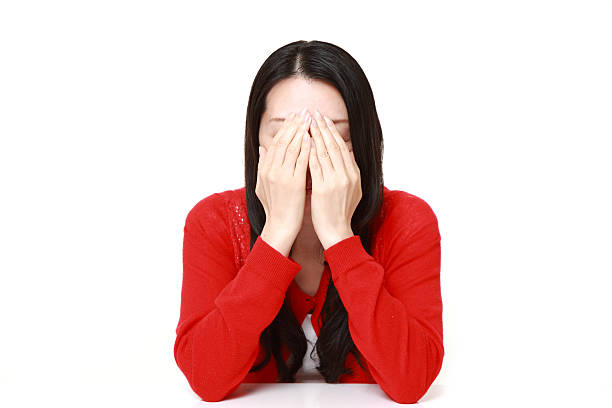 sad woman portrait of middle Japanese woman wearing a red cardigan on white background red blindfold stock pictures, royalty-free photos & images