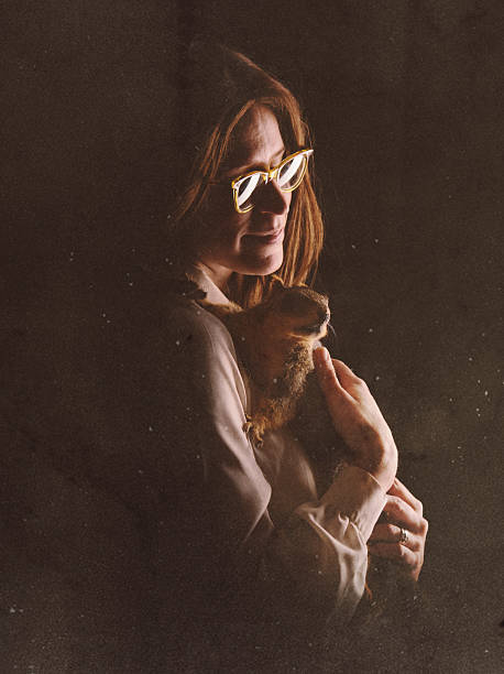 Faded Glamour Shot of Woman with Squirrel A vintage young woman with 1970's - 1980's style poses for a high school portrait holding her pet squirrel.  Retro-styled; INTENTIONAL DEGRADATION OF IMAGE AND LIGHTING. high school photos stock pictures, royalty-free photos & images