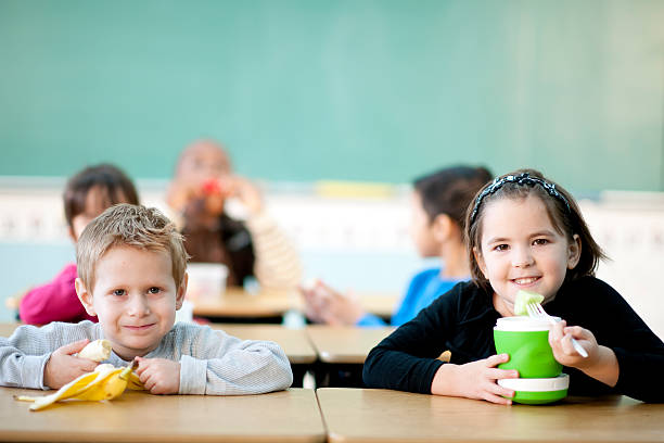 学生の学校で食べるランチ - 4th graders ストックフォトと画像