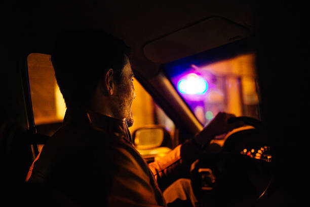istock Young man driving a car at night 470892558