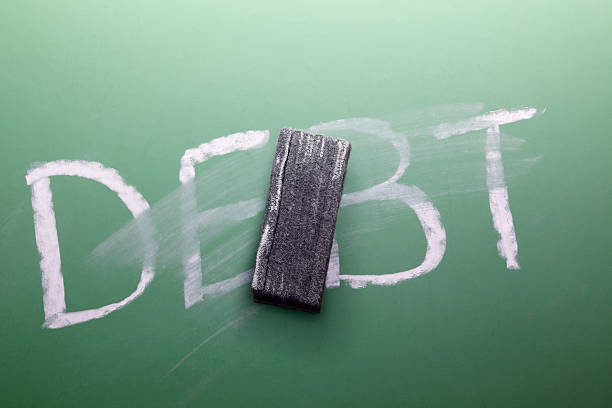 Erasing Debt The word debt partially erased on a chalkboard. board eraser photos stock pictures, royalty-free photos & images