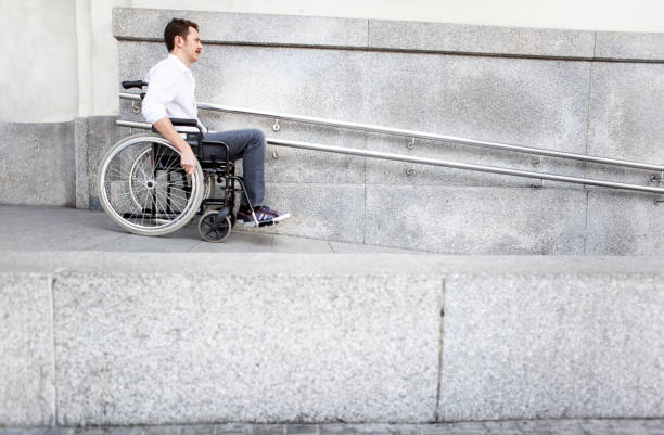man in a wheelchair using accessible ramp - 輪椅坡道 個照片及圖片檔