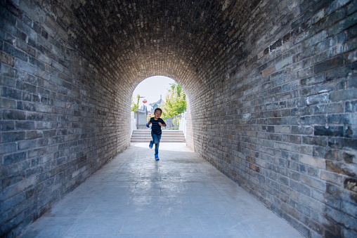 Little boy running through the tunnel.