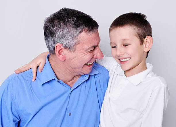 felice nonno e nipote maschio - whispering grandparent child grandfather foto e immagini stock