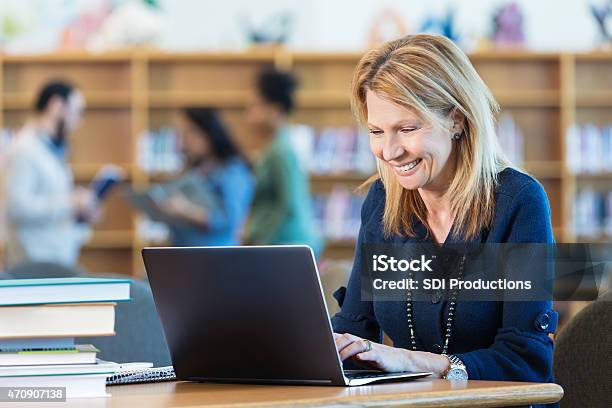 Mature Adult Woman Studying For College Class In Library Stock Photo - Download Image Now