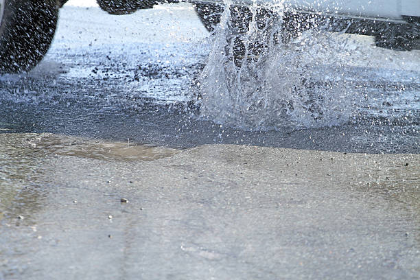 istock Water Splashes When A Car Hits Pothole On City Street 470907964