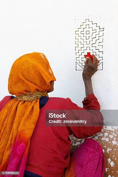 Senior Indian Lady In Sari Dress Decorates The Wall Of Stock Photo - Download Image Now