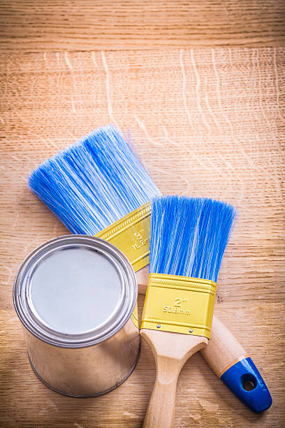 istock two paint brushes and can on wooden board 470909080