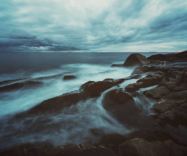 Dramatic skies over light surf on the Atlantic coast of Nova Scotia.  Long exposure shot in dusk light.