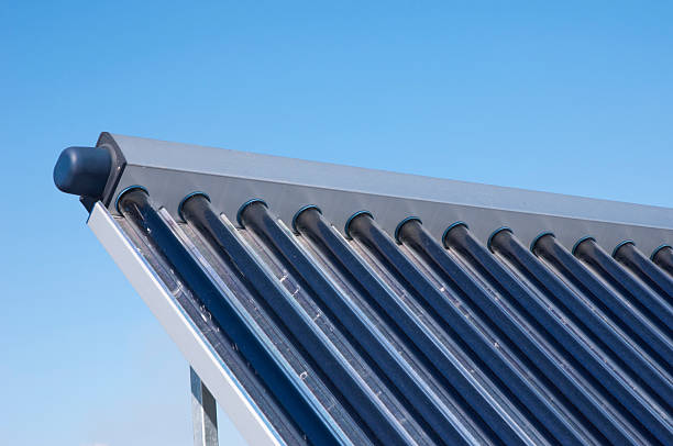 Closeup of solar water heating system on the house roof Closeup of vacuum solar water heating system on the house roof against blue sky.  solar heater stock pictures, royalty-free photos & images