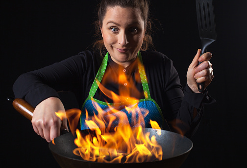 Fire cook woman - wok cooking