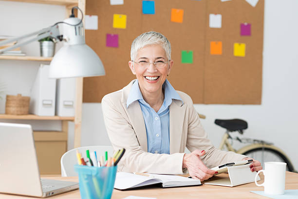istock Beautiful cheerful mature woman at office working on computer 470912428