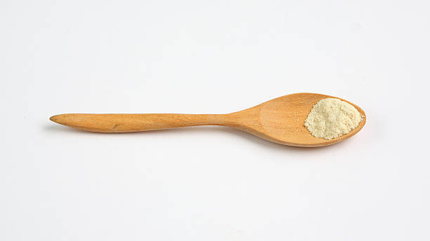 istock Powdered milk in wooden spoon over white background 470913214