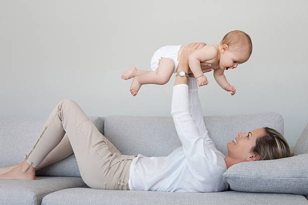 madre jugando con su bebé niño y haciendo exercices - exercices fotografías e imágenes de stock