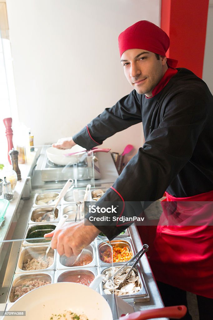 Welcome to my Food Bar Portrait of an uniformed young chef in a restaurant kitchen. 2015 Stock Photo