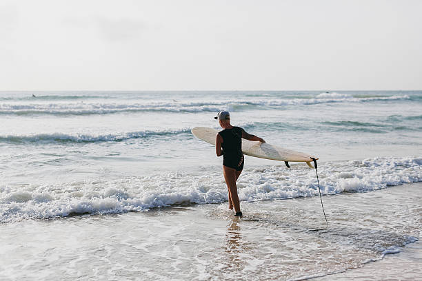 istock surfing woman with surfing board back view 470917914