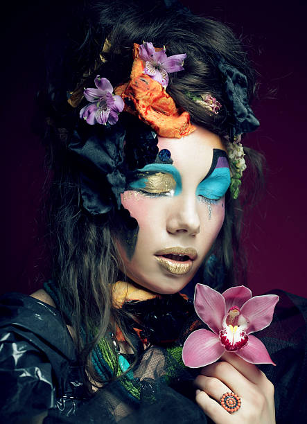 istock woman with creative make up holding pink flower 470918876