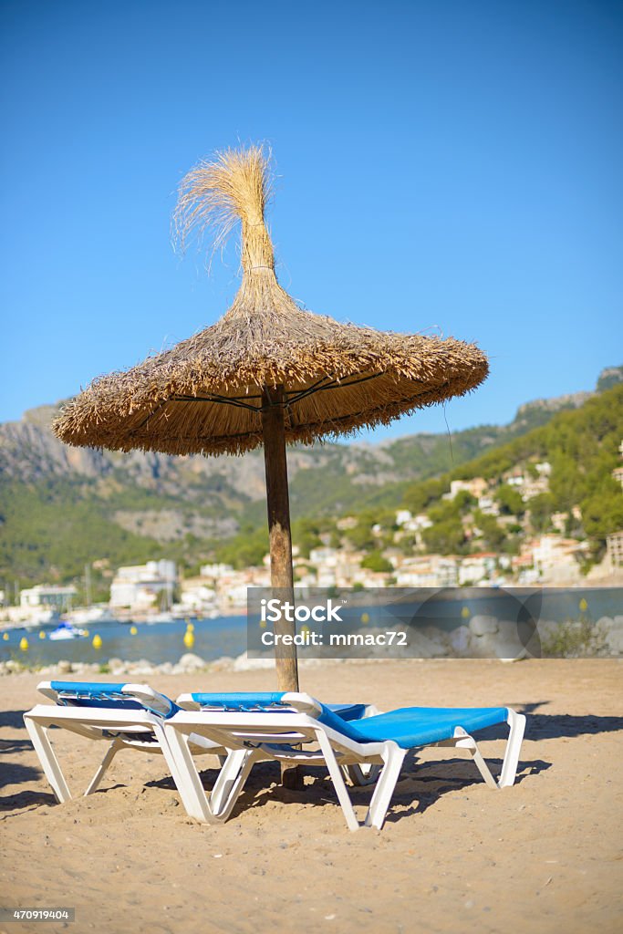 Beach with Parasol Mallorca, Spain Parasols on a beautiful and sunny beach of Mallorca the famous mediterranean island in the Balearic Islands arcipelago. This is a popular holiday destination for its beautiful sea and beach, as well as for its marvellous nature environment. 2015 Stock Photo