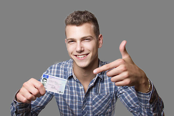 Young man showing off his driver license stock photo