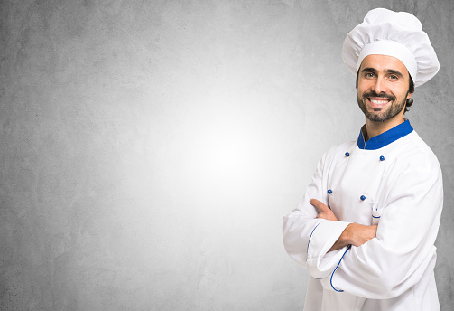 Smiling chef in front of a blank wall. Lots of copyspace