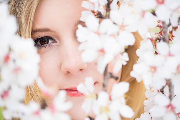 istock blond young girl between almond blossom 470930615