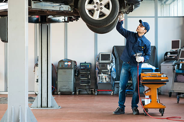 механик на работе в гараже - car examining mechanic auto mechanic стоковые фото и изображения