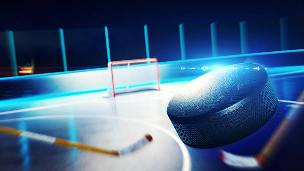 A low level point of view of an ice hockey match 3d rendered illustration of hockey ice rink and goal. The puck is flying on goal. ice hockey net stock pictures, royalty-free photos & images
