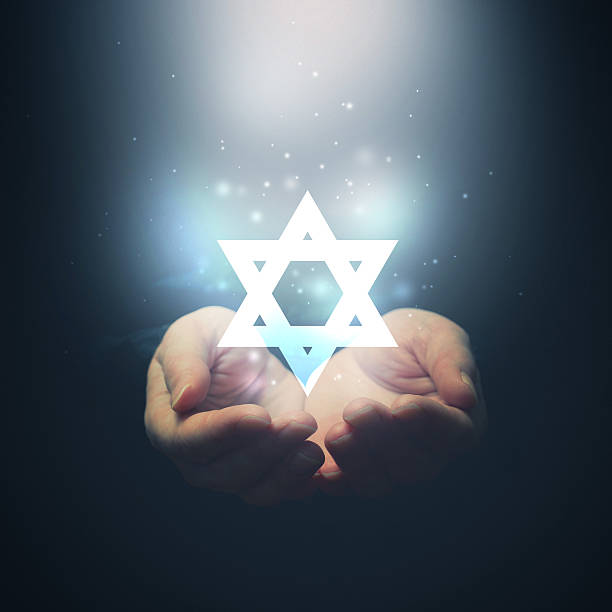 istock Female hands opening to light and David's star. 470933823