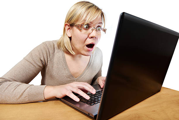 istock Frightened woman with glasses looking at laptop 470934214