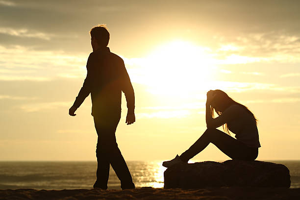 Couple silhouette breaking up a relation Couple silhouette breaking up a relation on the beach at sunset silhouette of bad boy stock pictures, royalty-free photos & images