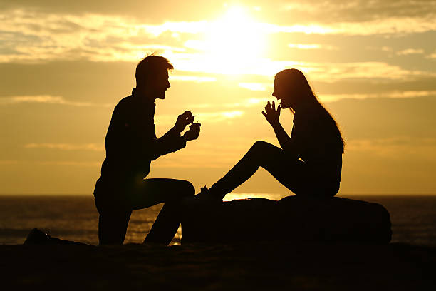 propuesta de hombre en la playa con petición de matrimonio - prometido fotografías e imágenes de stock