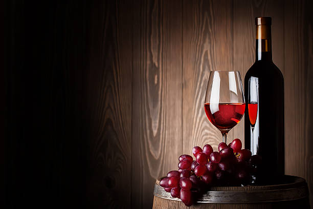 istock Bottle and glass of red wine with grapes 470942244