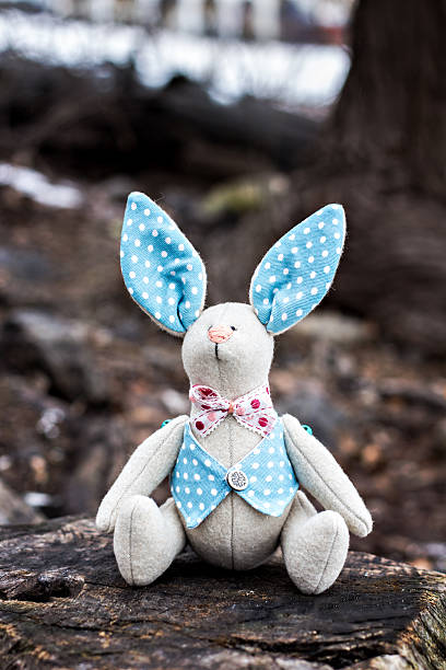 istock Soft toy - bunny sitting on an old tree. 470942274