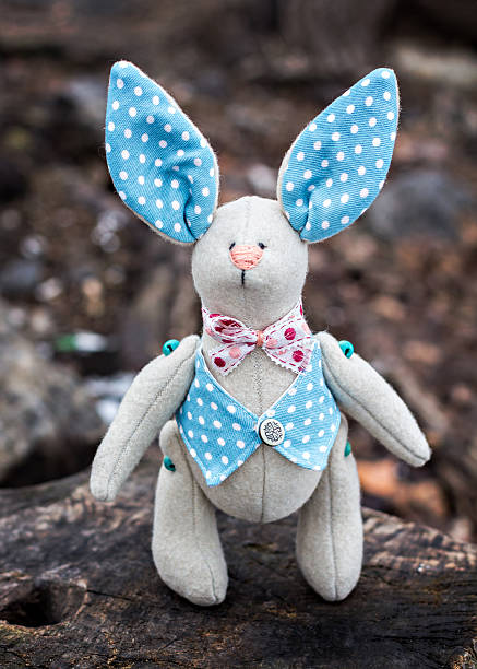 istock Soft toy - bunny sitting on an old tree. 470942280