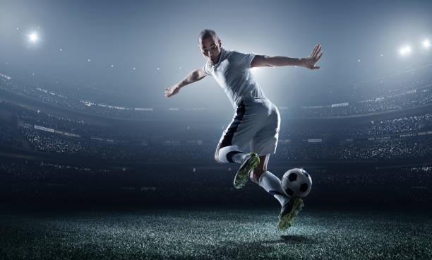 istock Soccer player kicking ball in stadium 470943610