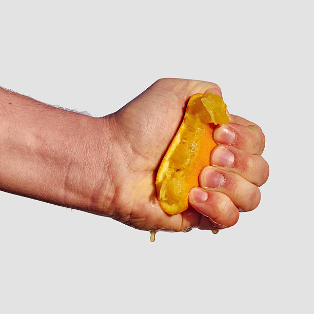 istock Man's hand squeezes the juice from the orange 470944192
