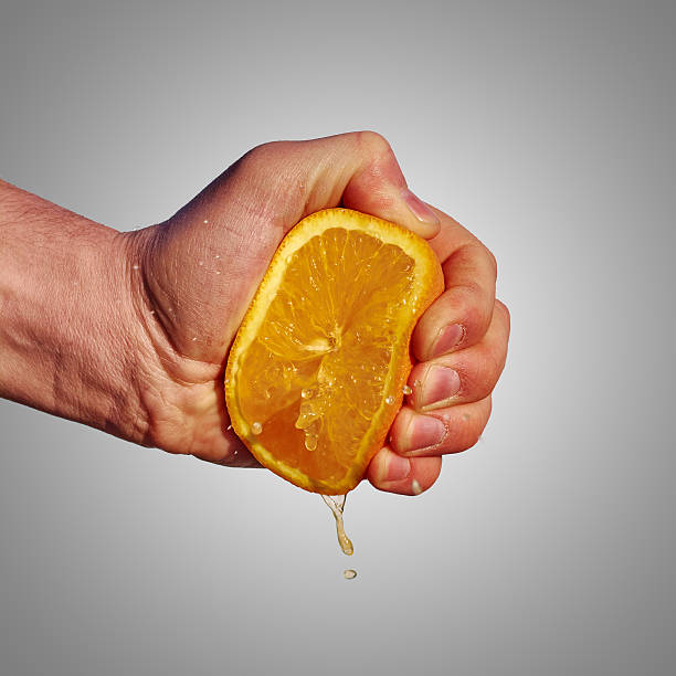 istock Man's hand squeezes the juice from the orange 470944204