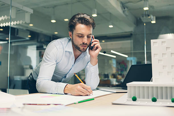 istock Male Designer talking on smart phone in office. 470944424