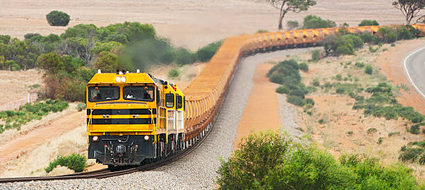 istock Empty iron ore train with orange wagons in hills 470950854