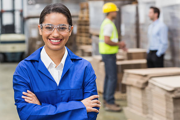 Manager wearing protective mask looking at camera Manager wearing protective mask looking at camera in a large warehouse protective eyewear stock pictures, royalty-free photos & images