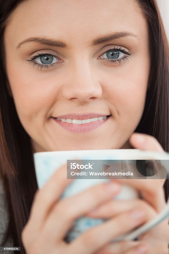 Smiling girl holding a cup of coffee Smiling brunette holding a cup of coffee and looking at camera Adult Stock Photo