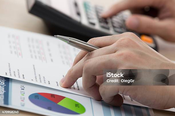 Businessman Calculating And Checking Articles Of Agreement Stock Photo - Download Image Now