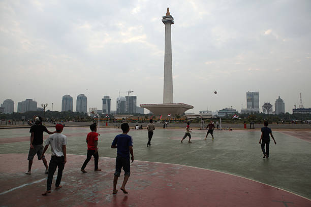 дети, играть в футбол, джакарта, индонезия. - indonesia football стоковые фото и изображения