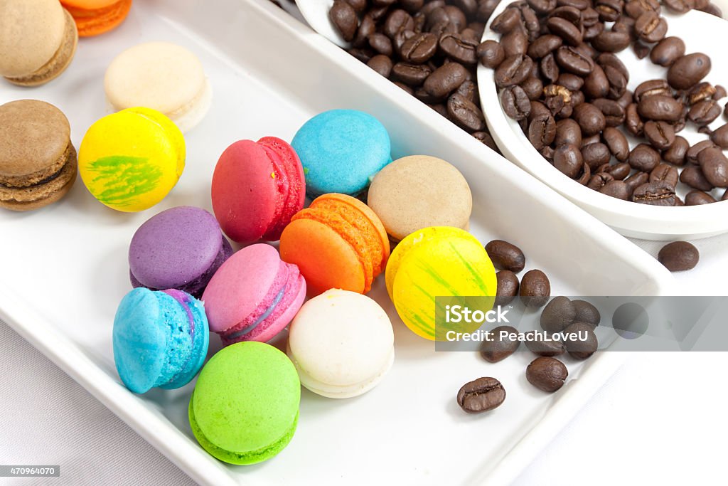 Coffee bean and mini macaroon colorful Coffee bean and mini macaroon colorful in white caramic plate on white background 2015 Stock Photo