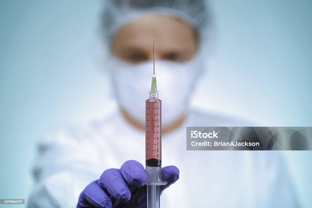 Doctor holding syringe Doctor, male nurse or anesthetist with surgical needle giving a medical injection concept for healthcare or vaccination Anesthetic Stock Photo